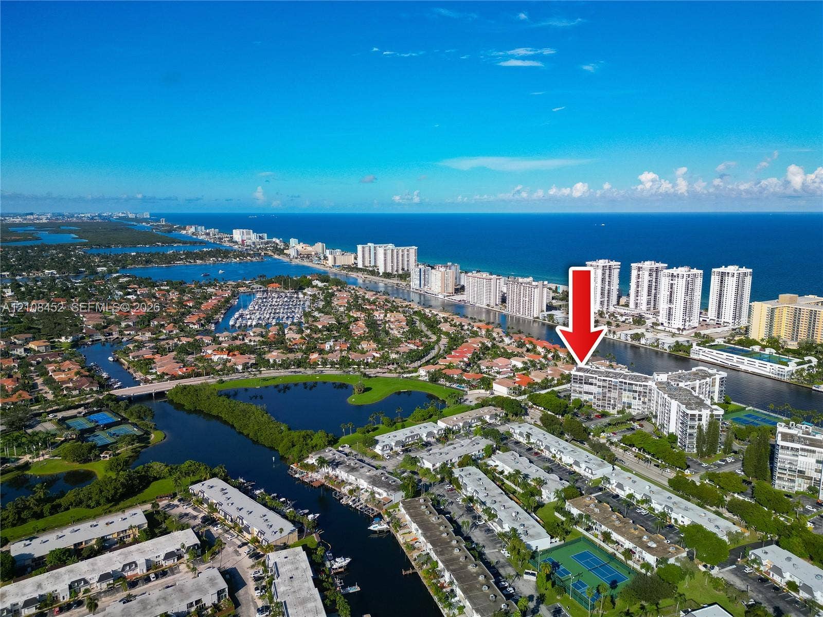 1000 Parkview Drive, #809, Hallandale Beach, FL 33009 Aerial perspective of a multi-story residential building featuring waterfront positioning, proximity to coastal shoreline, boat slips, and tennis courts