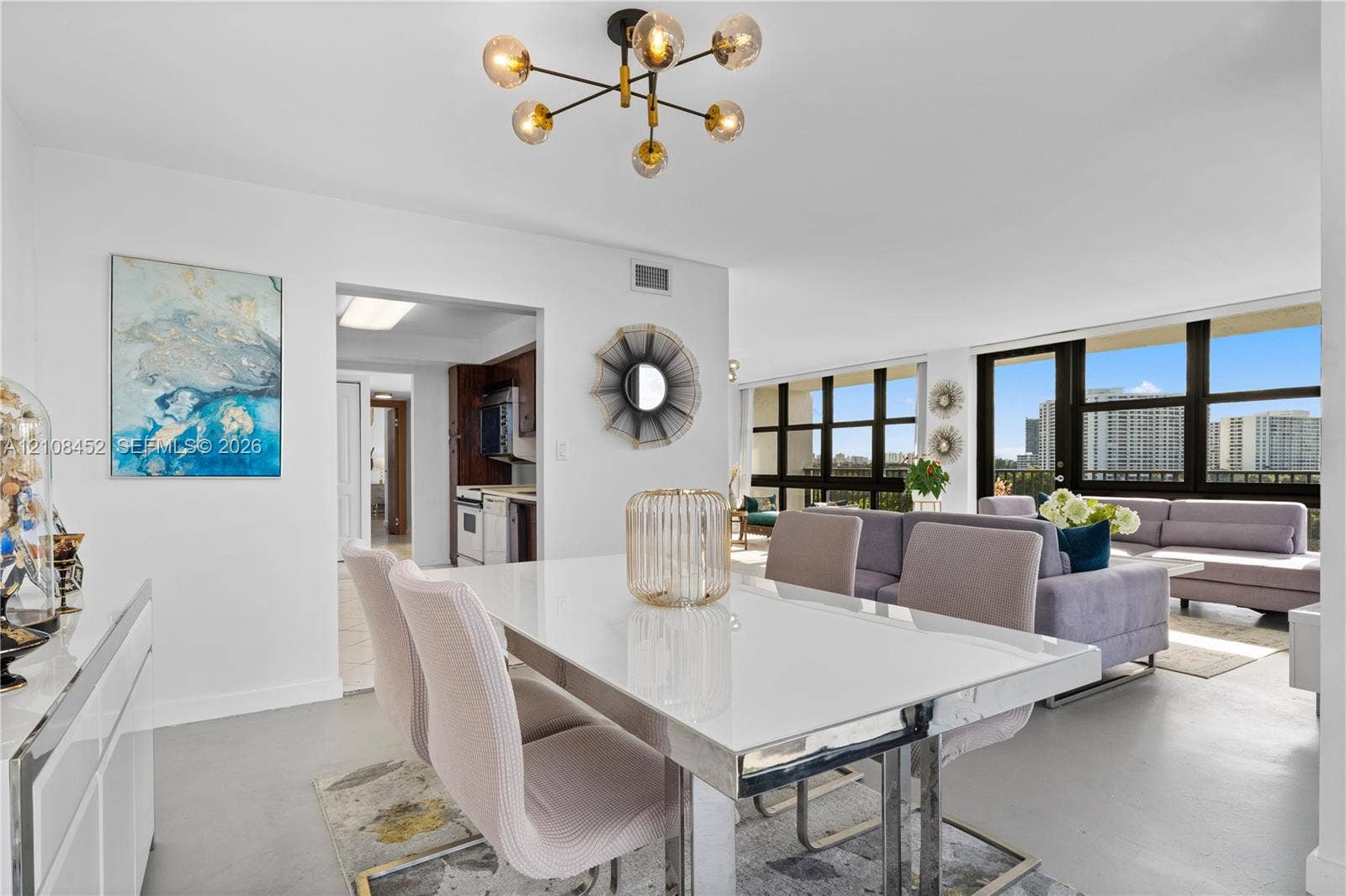 1000 Parkview Drive, #809, Hallandale Beach, FL 33009 Modern multi-arm sputnik chandelier, floor-to-ceiling windows with external terrace access, and smooth-finish flooring