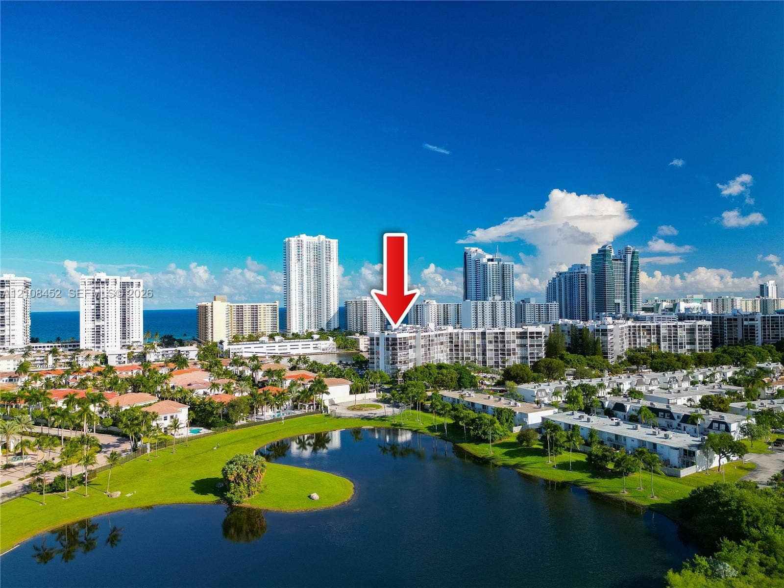 1000 Parkview Drive, #809, Hallandale Beach, FL 33009 Aerial perspective of mid-rise condominium building situated on a waterfront lot featuring extensive green space and mature palm trees