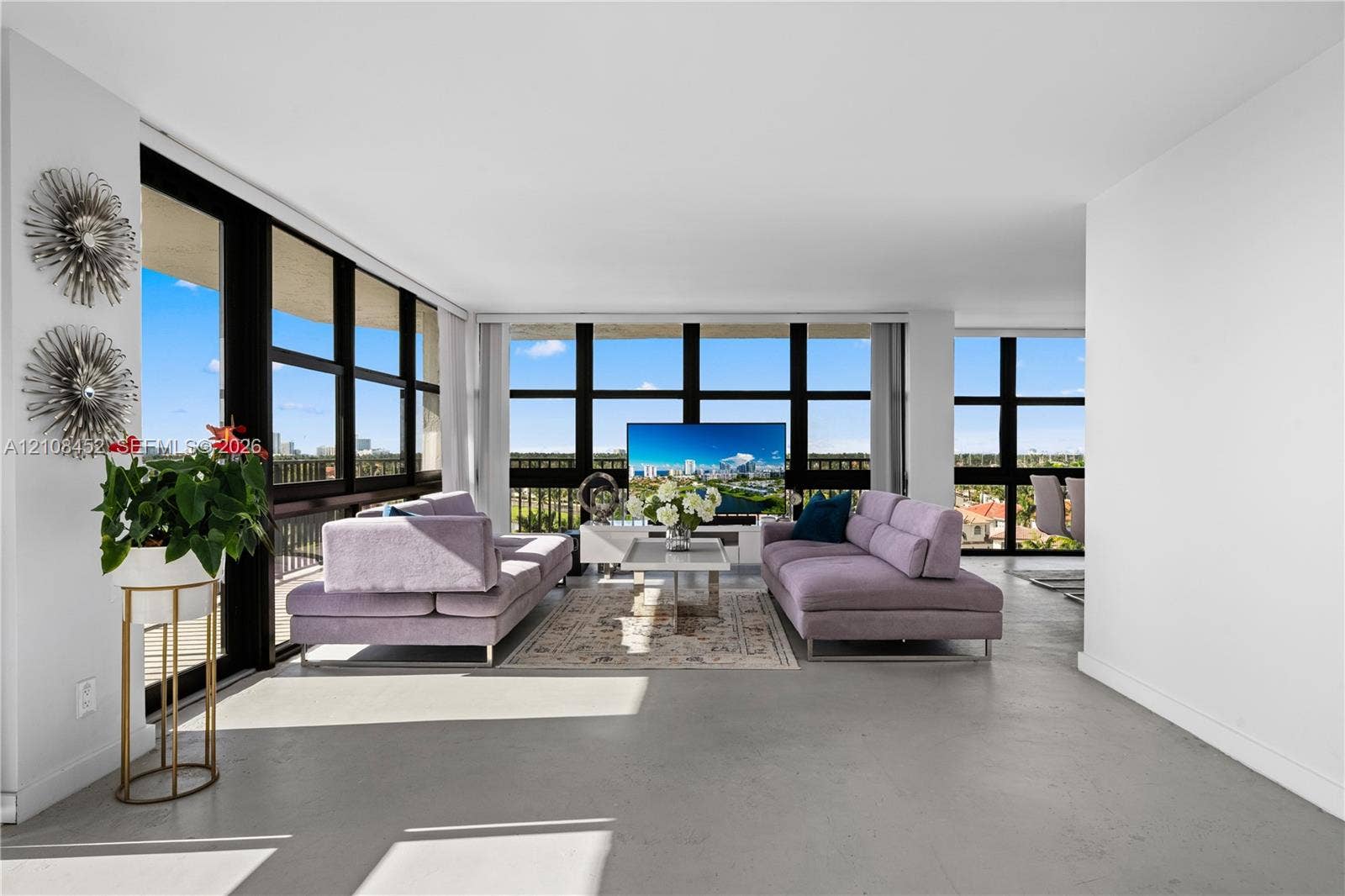 1000 Parkview Drive, #809, Hallandale Beach, FL 33009 Open-concept interior featuring floor-to-ceiling windows with expansive exterior scenery, polished concrete flooring, and metal-framed balcony access