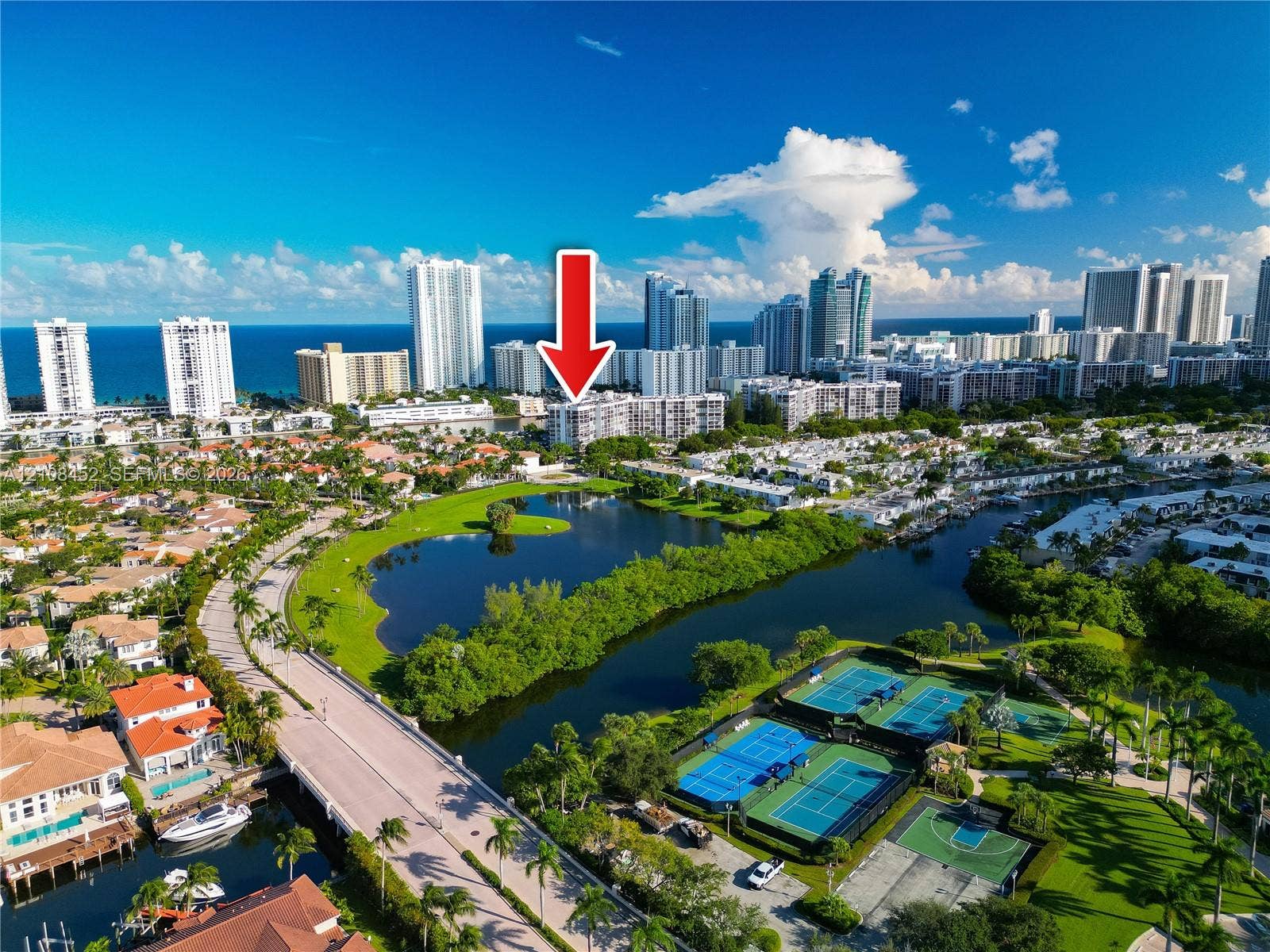 1000 Parkview Drive, #809, Hallandale Beach, FL 33009 Aerial perspective of residential building with proximity to water features, tennis courts, and basketball court