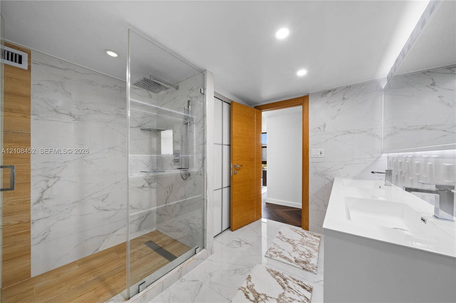 1000 Parkview Drive, #809, Hallandale Beach, FL 33009 Walk-in shower with a glass enclosure, wood-finish flooring, and wall-mounted rain shower head
