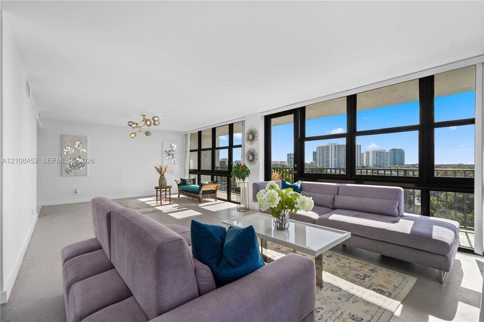 1000 Parkview Drive, #809, Hallandale Beach, FL 33009 Floor-to-ceiling windows, polished concrete flooring, multi-arm flush-mount lighting, and integrated exterior balcony access