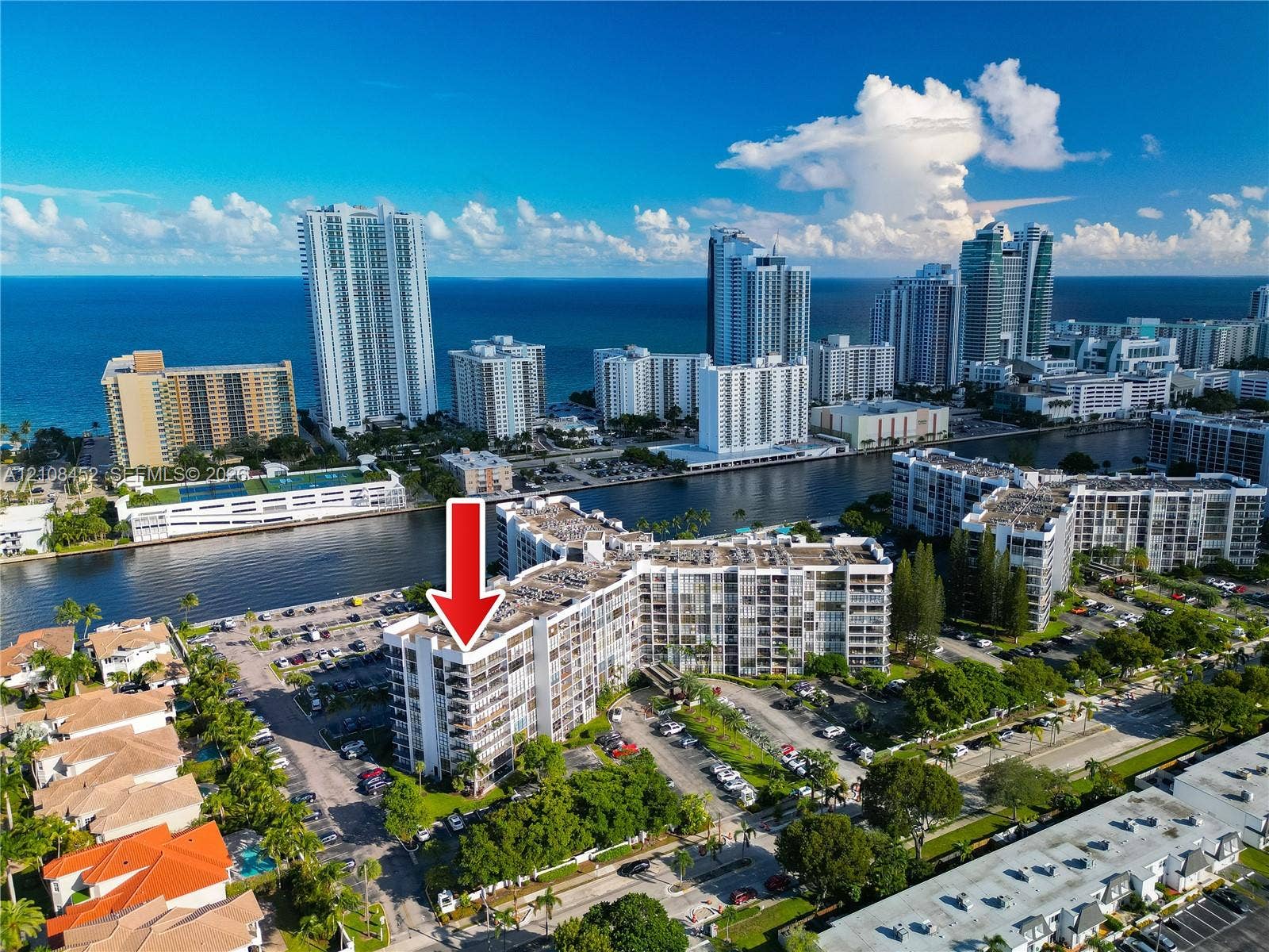 1000 Parkview Drive, #809, Hallandale Beach, FL 33009 Aerial perspective of a multi-story residential building featuring wrap-around private balconies, proximity to the coastline, and waterfront positioning along a canal