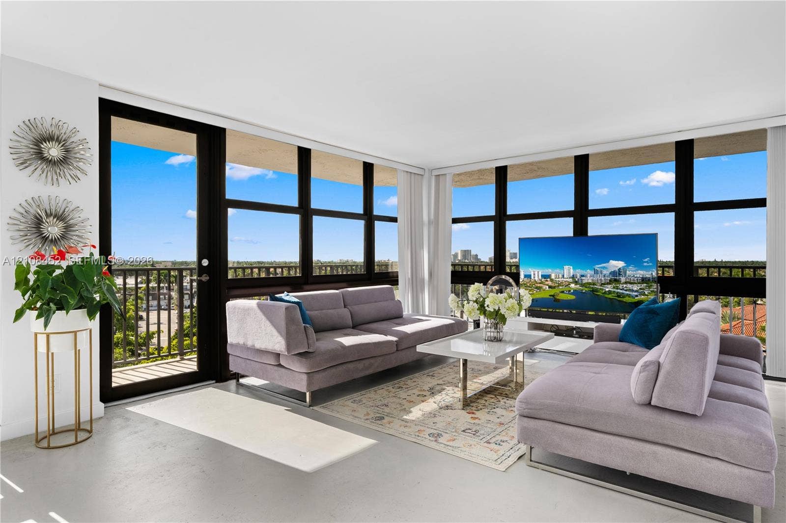 1000 Parkview Drive, #809, Hallandale Beach, FL 33009 Floor-to-ceiling windows with black framing, integrated balcony access, and neutral polished concrete flooring
