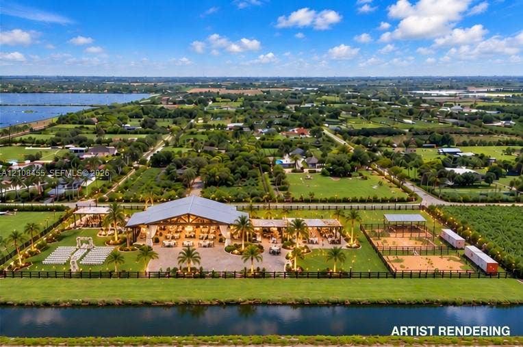 Extensive grounds featuring an open-air pavilion, landscaped palm gardens, multiple fenced enclosures, and waterfront access