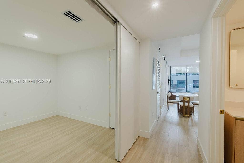90 NE 32nd Street, #511, Miami, FL 33127 Interior space featuring wood-finish flooring, recessed lighting, and a large sliding door with a mirror finish