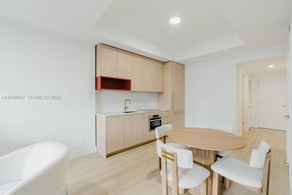 90 NE 32nd Street, #511, Miami, FL 33127 Kitchen featuring light wood-finish cabinetry, white countertop, integrated refrigerator, built-in cooktop and wall oven, and recessed ceiling lighting