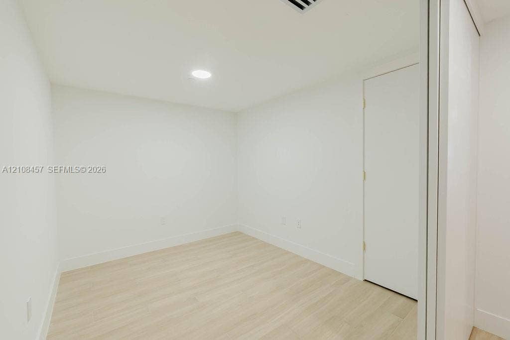 90 NE 32nd Street, #511, Miami, FL 33127 Interior space featuring light-toned wood-finish flooring, crisp white walls, recessed ceiling lighting, and a closet with sliding doors