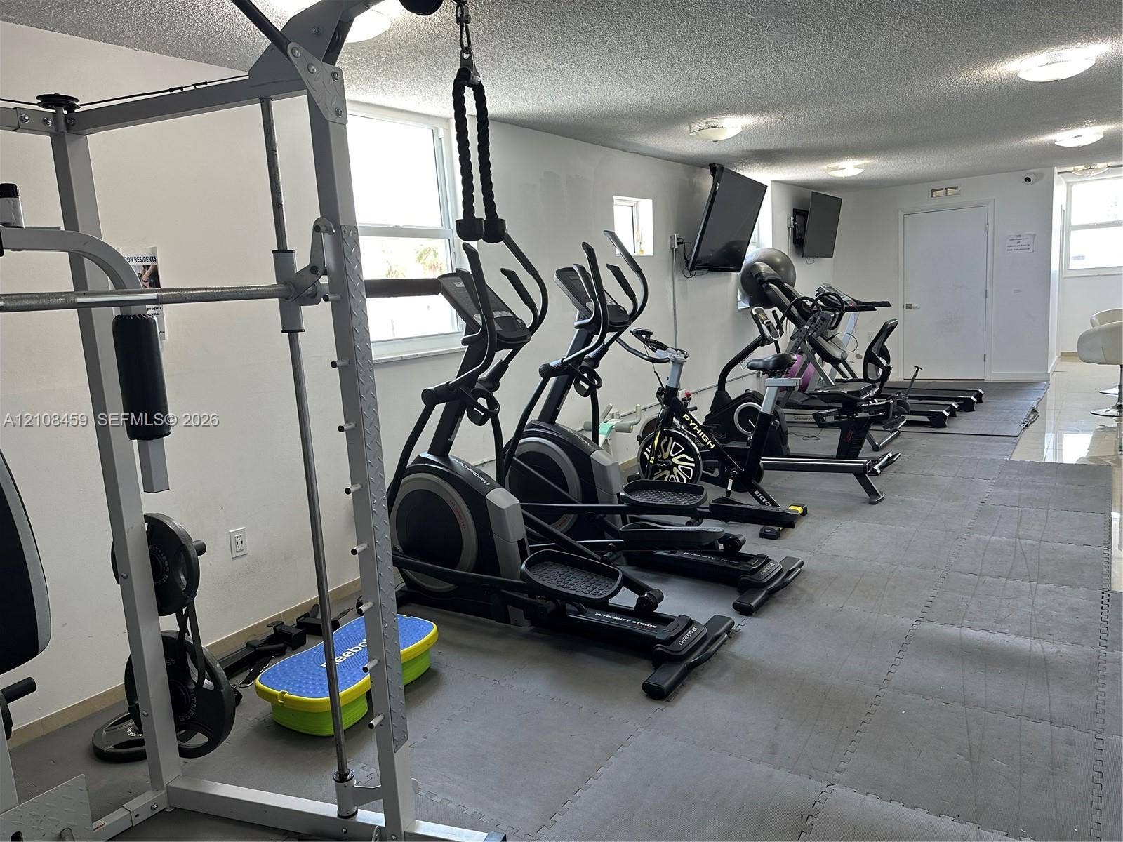 720 Collins Avenue, #206, Miami Beach, Miami Beach, FL 33139 Fitness area featuring tile flooring, ceiling-mounted lighting, and wall-mounted televisions