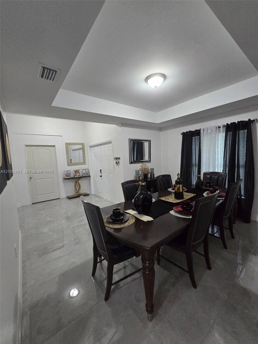 Tray ceiling, large-format tile flooring, and multi-panel interior doors