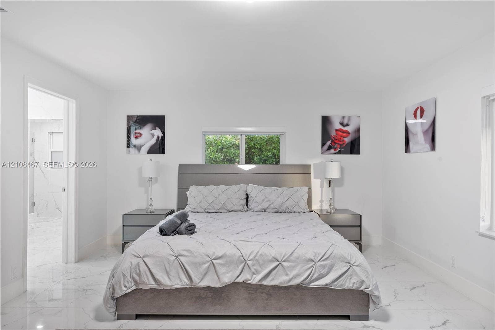 Interior space featuring high-gloss, large-format tile flooring with marble-pattern veining and a centered window