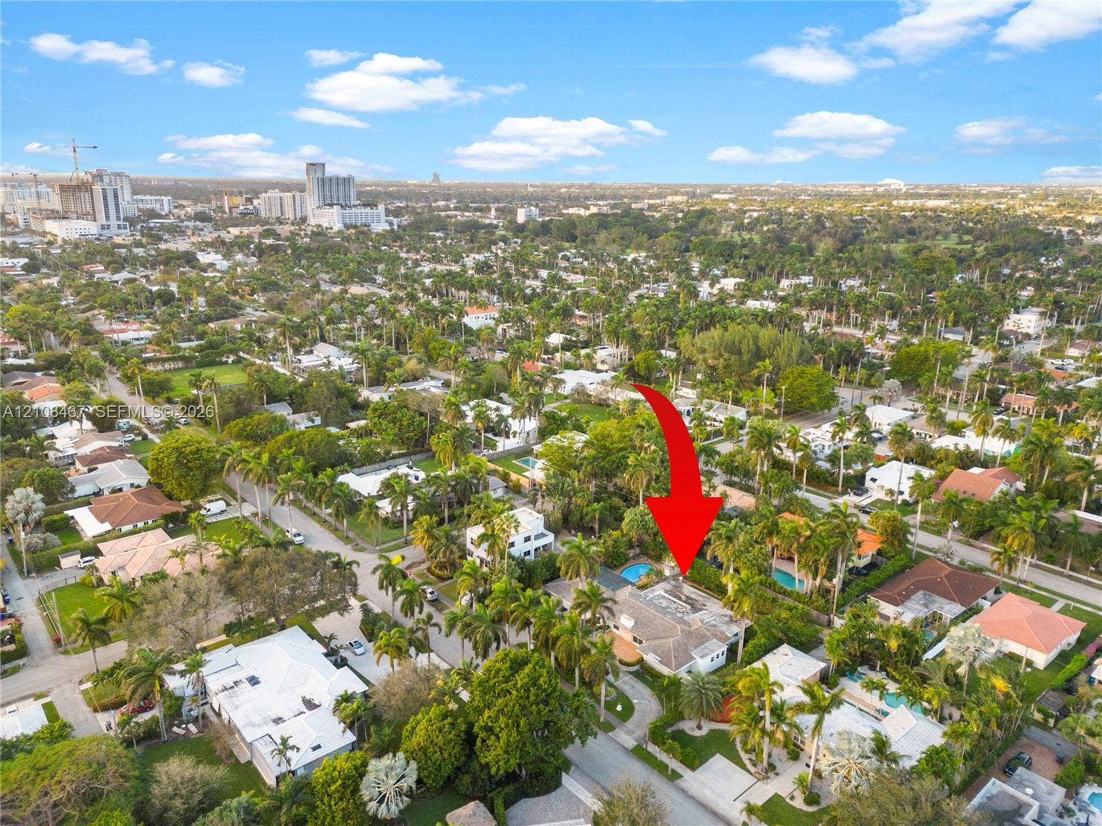 Aerial perspective showcasing a residential property featuring a private swimming pool, mature perimeter landscaping, and a paved driveway