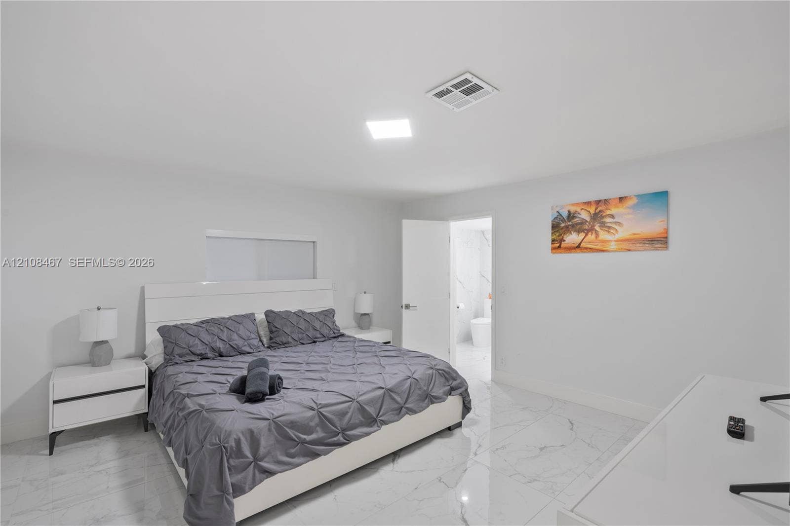 Large-format tile flooring with a neutral-toned veined finish, recessed lighting, and crisp white wall surfaces