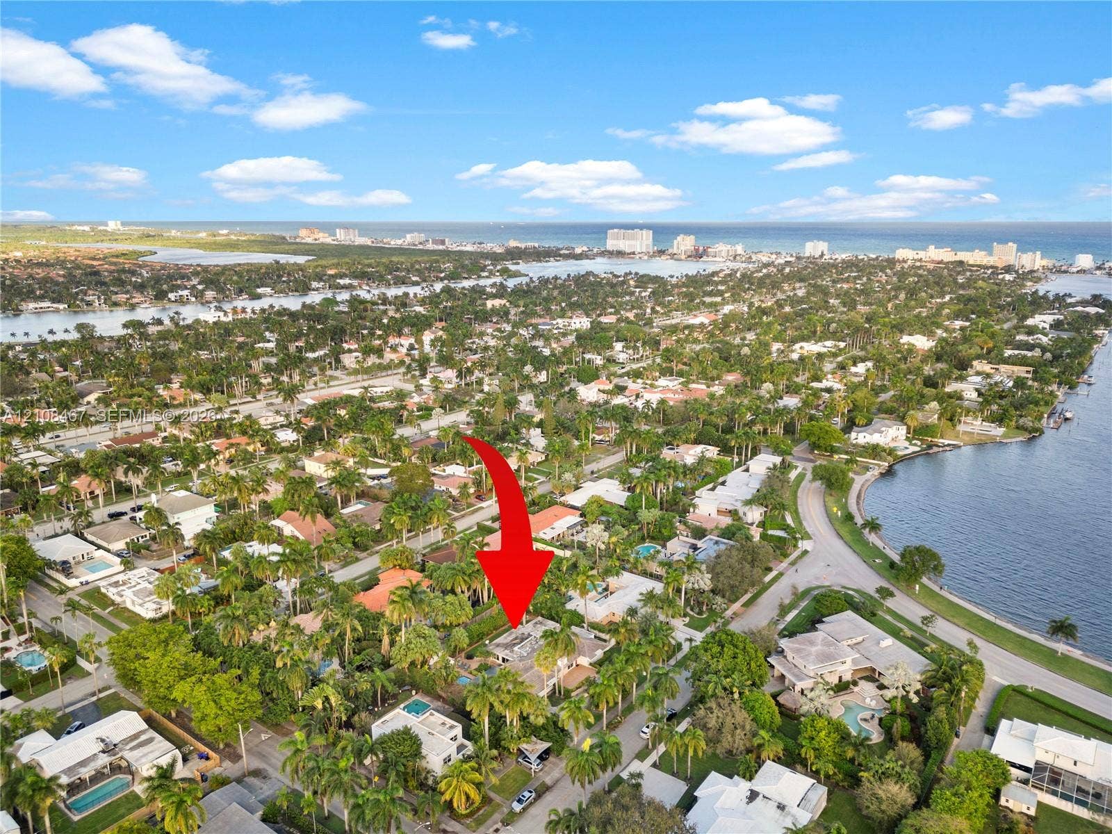 Aerial perspective featuring a residential lot situated within a coastal neighborhood, highlighted by proximity to regional waterways and established tropical landscaping