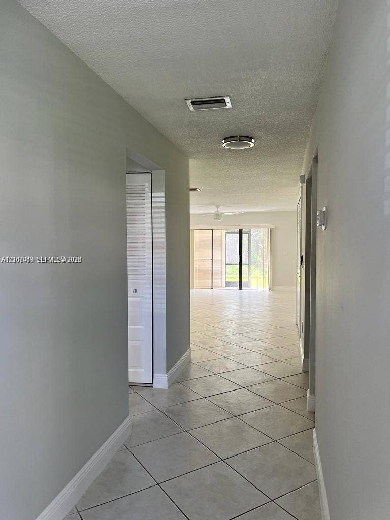 21362 Juego Circle, #33E, Boca Raton, Boca Raton, FL 33433 Entrance Hallway featuring neutral-toned walls, diagonal -format ceramic tile flooring, and integrated ceiling lighting