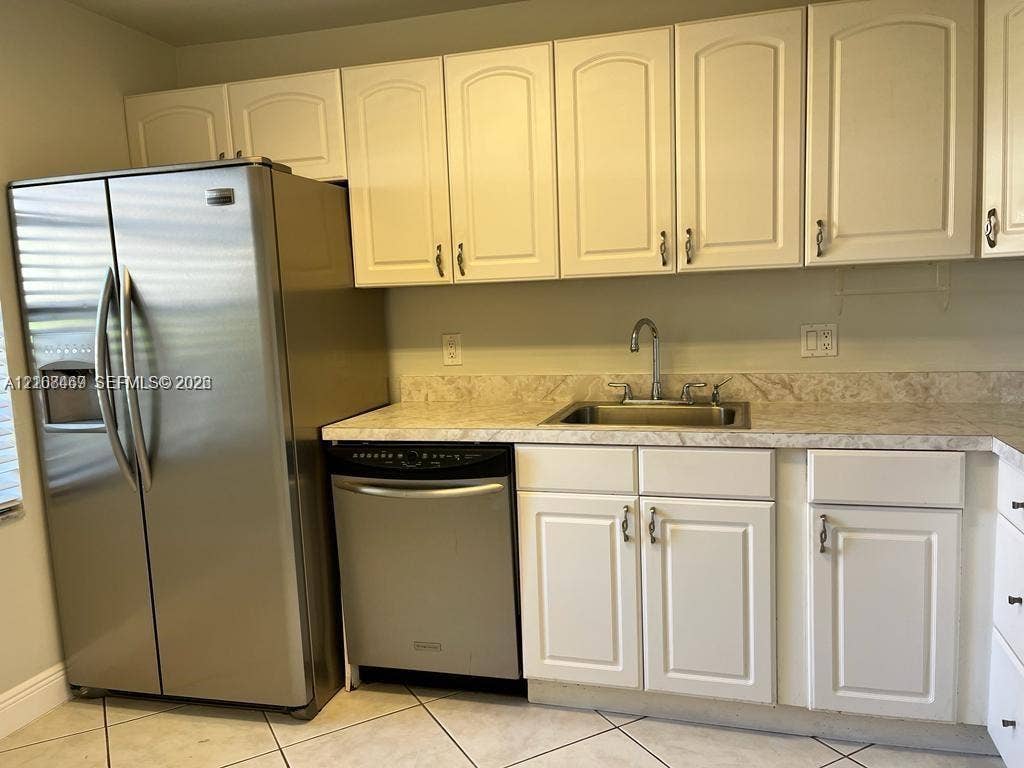 21362 Juego Circle, #33E, Boca Raton, Boca Raton, FL 33433 Kitchen featuring white shaker-style cabinetry, neutral patterned countertops, stainless steel appliances which includes side-by-side refrigerator, dishwasher, electric range and microwave-hood