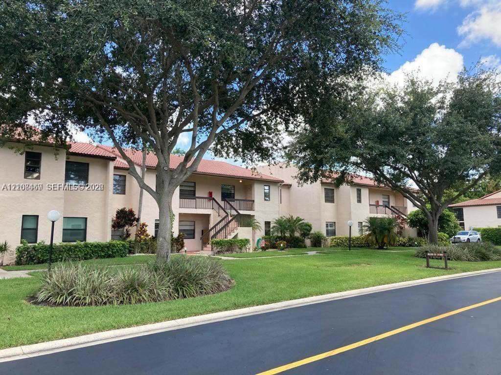 21362 Juego Circle, #33E, Boca Raton, Boca Raton, FL 33433 Stucco exterior with red tile roofing, covered entryways, manicured landscaping featuring mature trees