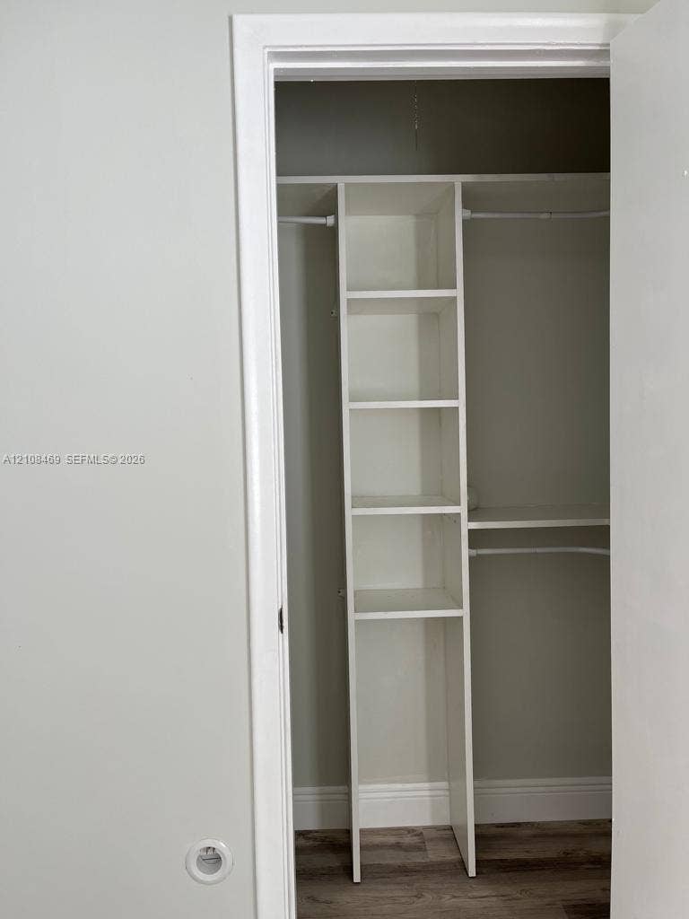 21362 Juego Circle, #33E, Boca Raton, Boca Raton, FL 33433 Closet featuring built-in vertical shelving and dual metal hanging rods.