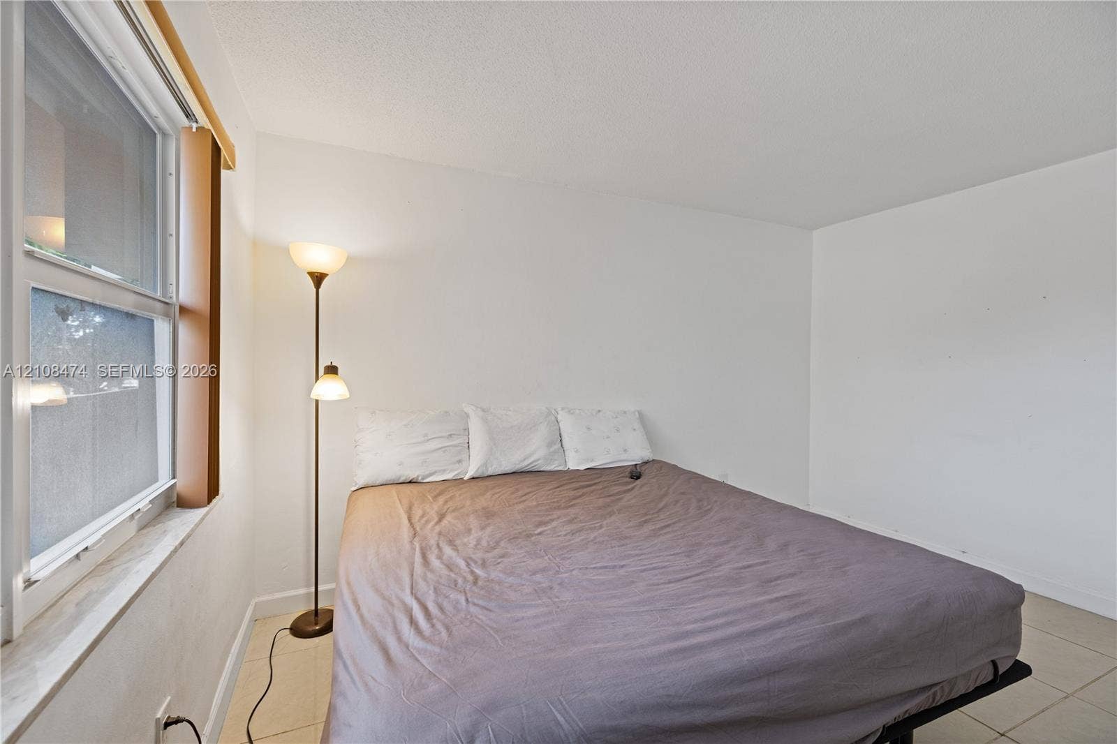 1501 NE 191st Street, #C216, Miami, FL 33179 Neutral-toned tile flooring and single-hung window with a deep sill