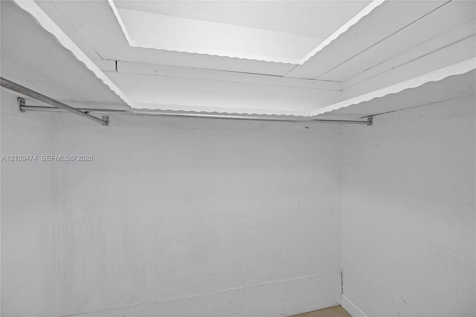 1501 NE 191st Street, #C216, Miami, FL 33179 Storage area featuring a tray ceiling with recessed lighting and a wall-mounted metal garment rod
