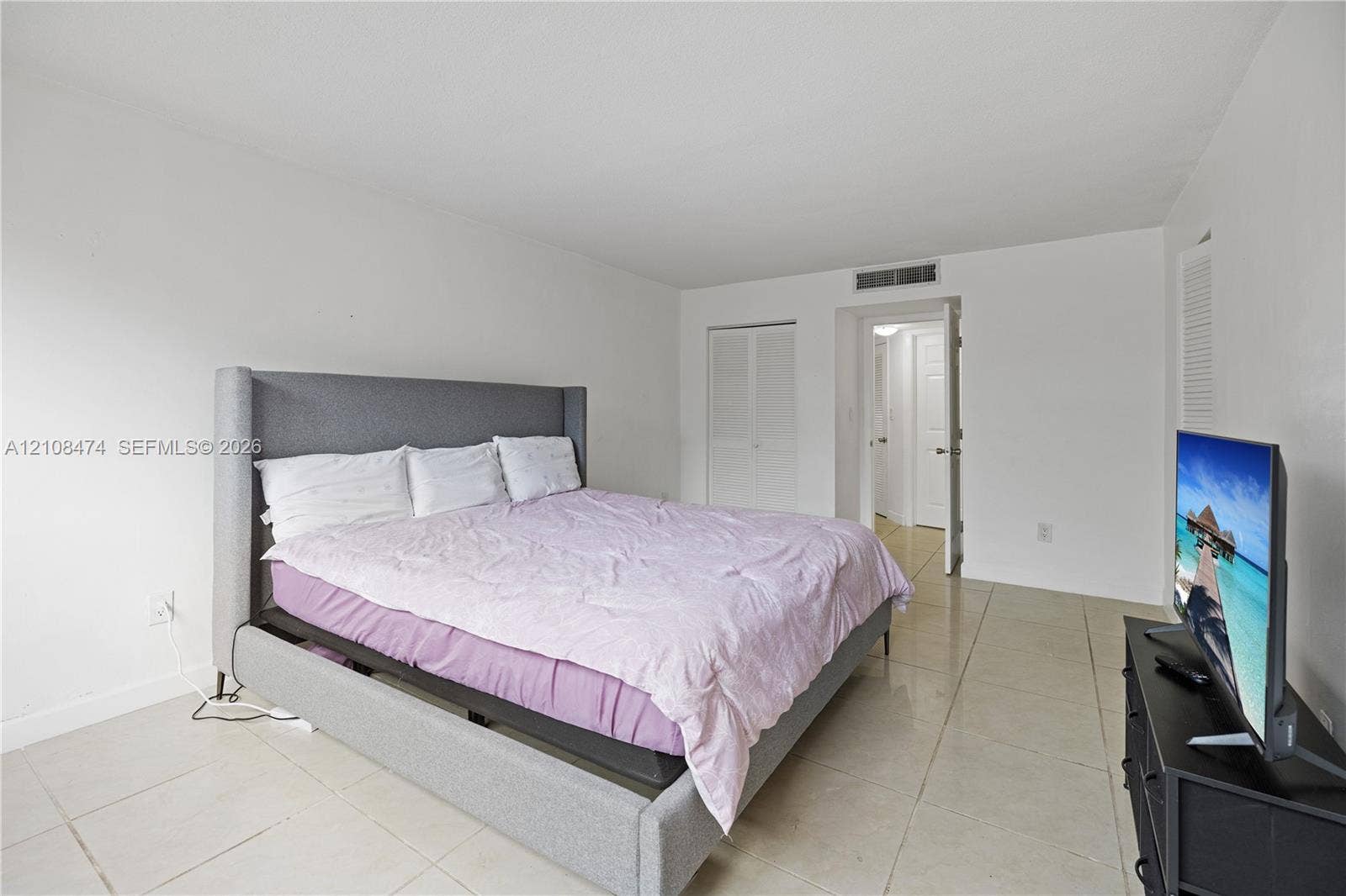 1501 NE 191st Street, #C216, Miami, FL 33179 Neutral-toned tile flooring, white wall finishes, and bi-fold closet doors