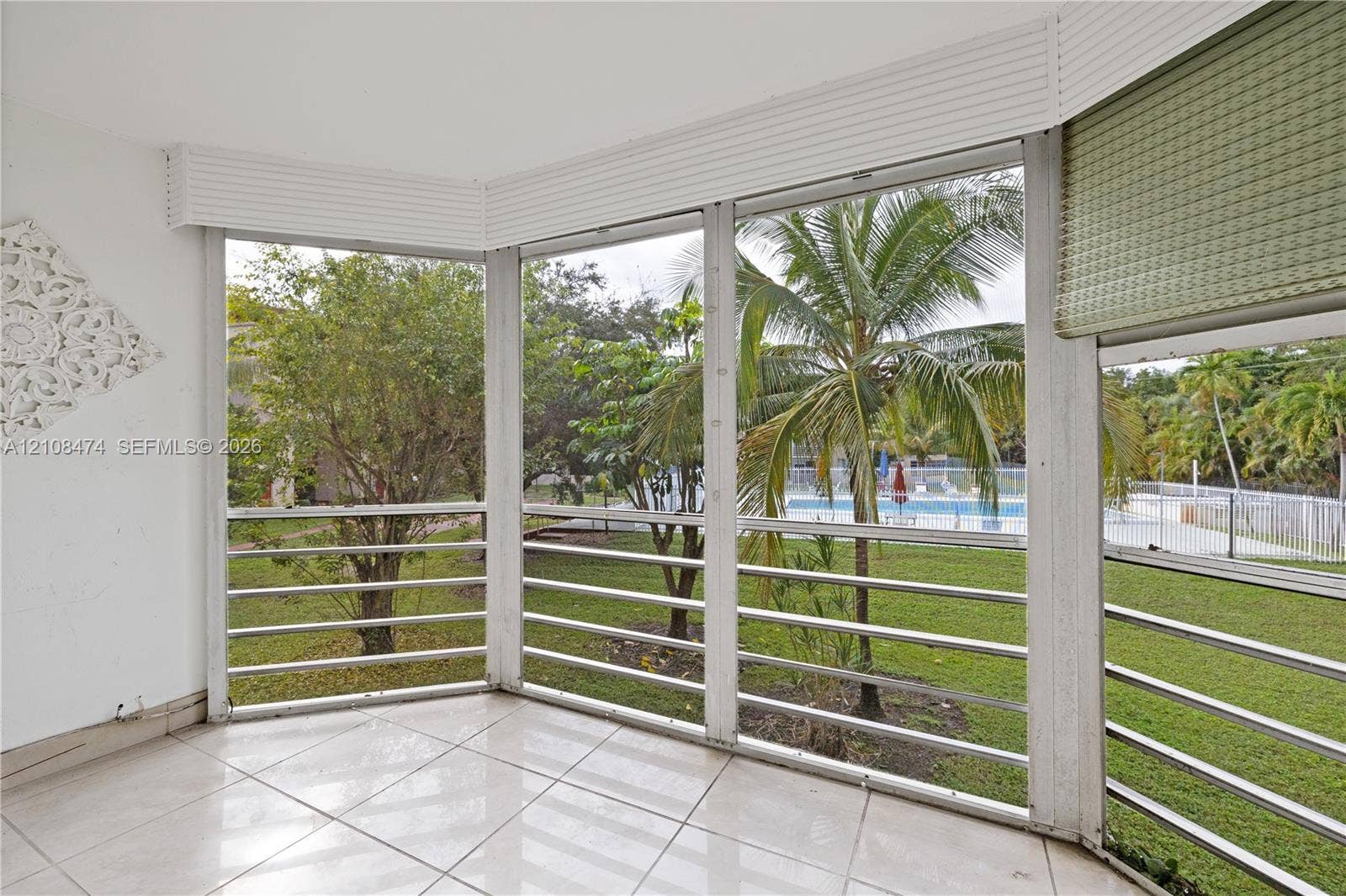 1501 NE 191st Street, #C216, Miami, FL 33179 Enclosed porch featuring tile flooring, expansive floor-to-ceiling screen panels, and white framing