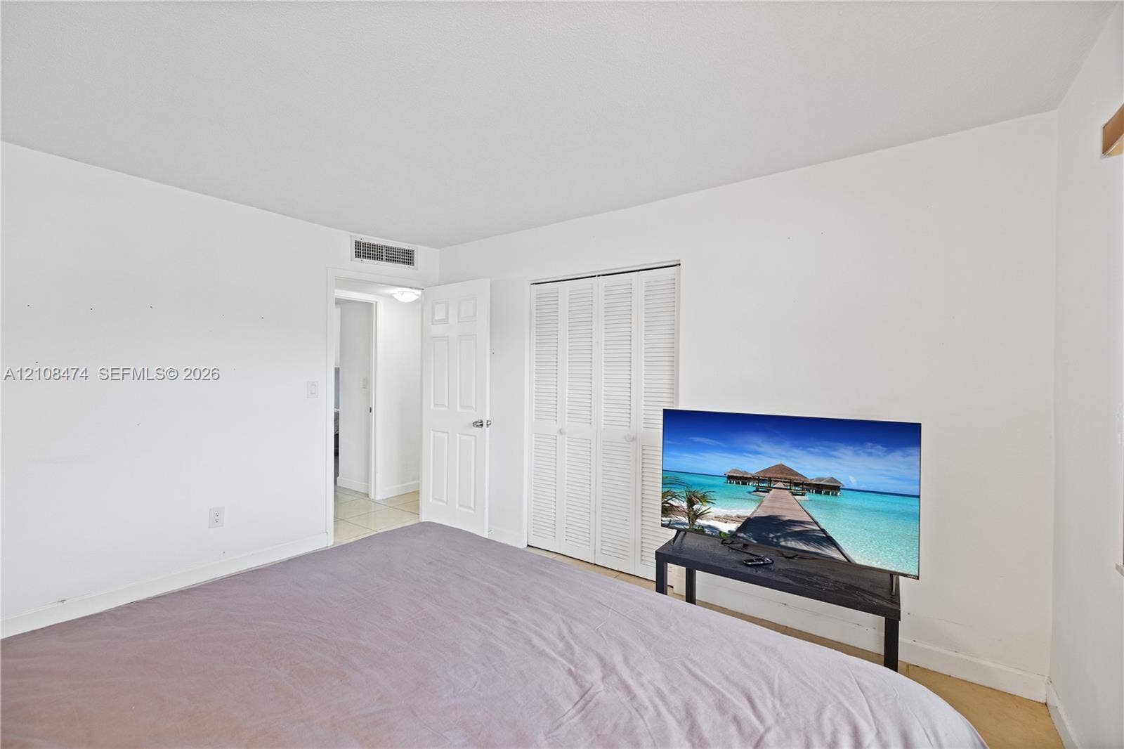 1501 NE 191st Street, #C216, Miami, FL 33179 Neutral interior room featuring white walls, a white bi-fold louvered closet door, and a white interior swing door