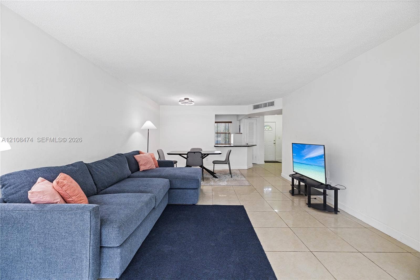 1501 NE 191st Street, #C216, Miami, FL 33179 Neutral-toned tile flooring, white wall finishes, and a kitchen pass-through counter