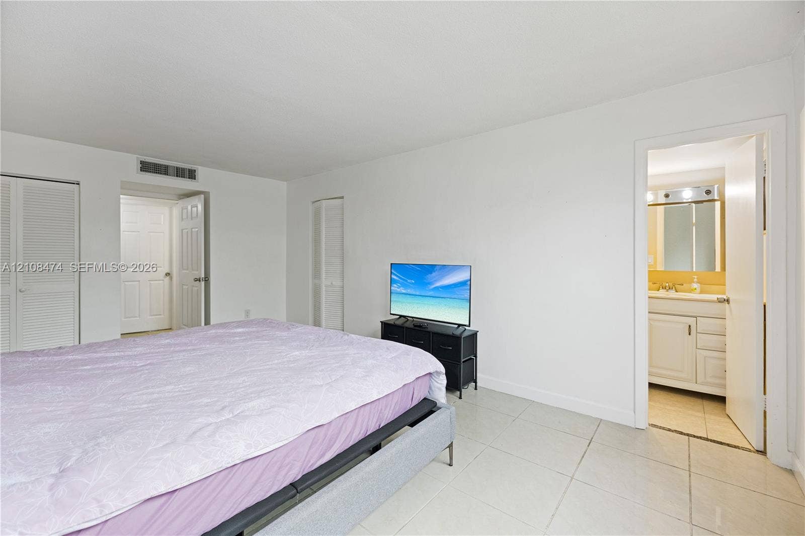 1501 NE 191st Street, #C216, Miami, FL 33179 Neutral-toned large-format tile flooring, multi-panel doors, and bifold closet doors