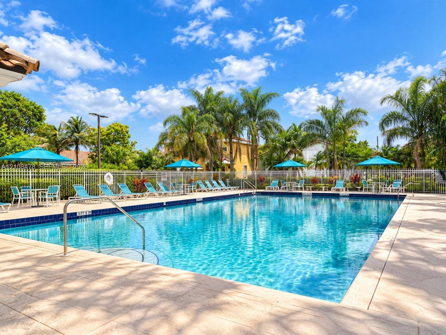 2233 NW 162nd Terrace, Pembroke Pines, FL 33028 Swimming pool with a paved deck, metal perimeter fencing, and mature palm trees