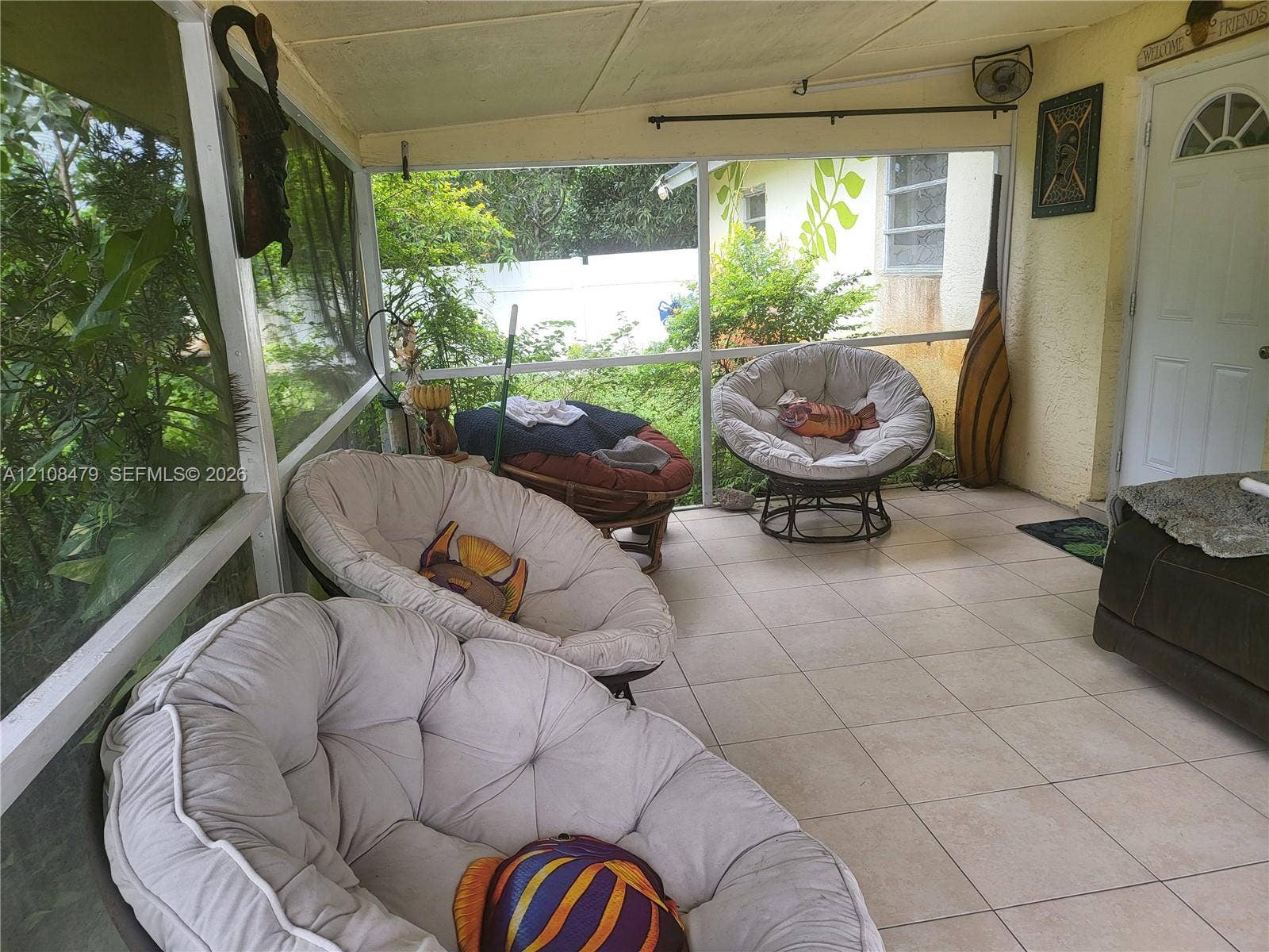 Enclosed patio featuring floor-to-ceiling screens, ceramic tile flooring, and a solid-core exterior door