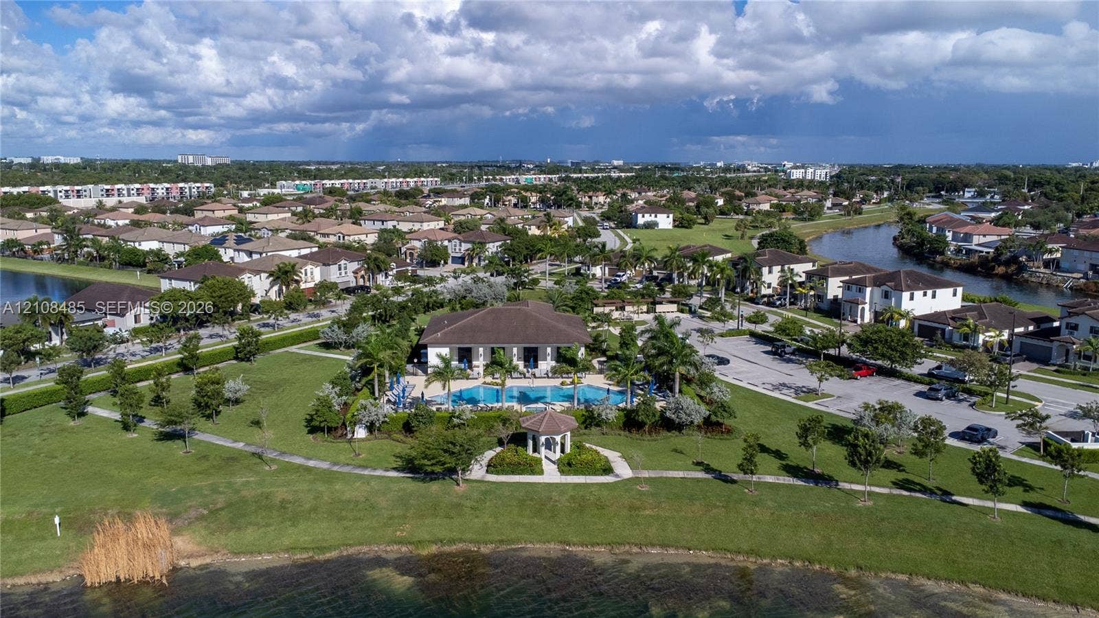 10217 SW 231st Lane, Miami, FL 33190 Aerial perspective of a community facility featuring a swimming pool, covered gazebo, surrounding landscaped grounds, and a paved parking area
