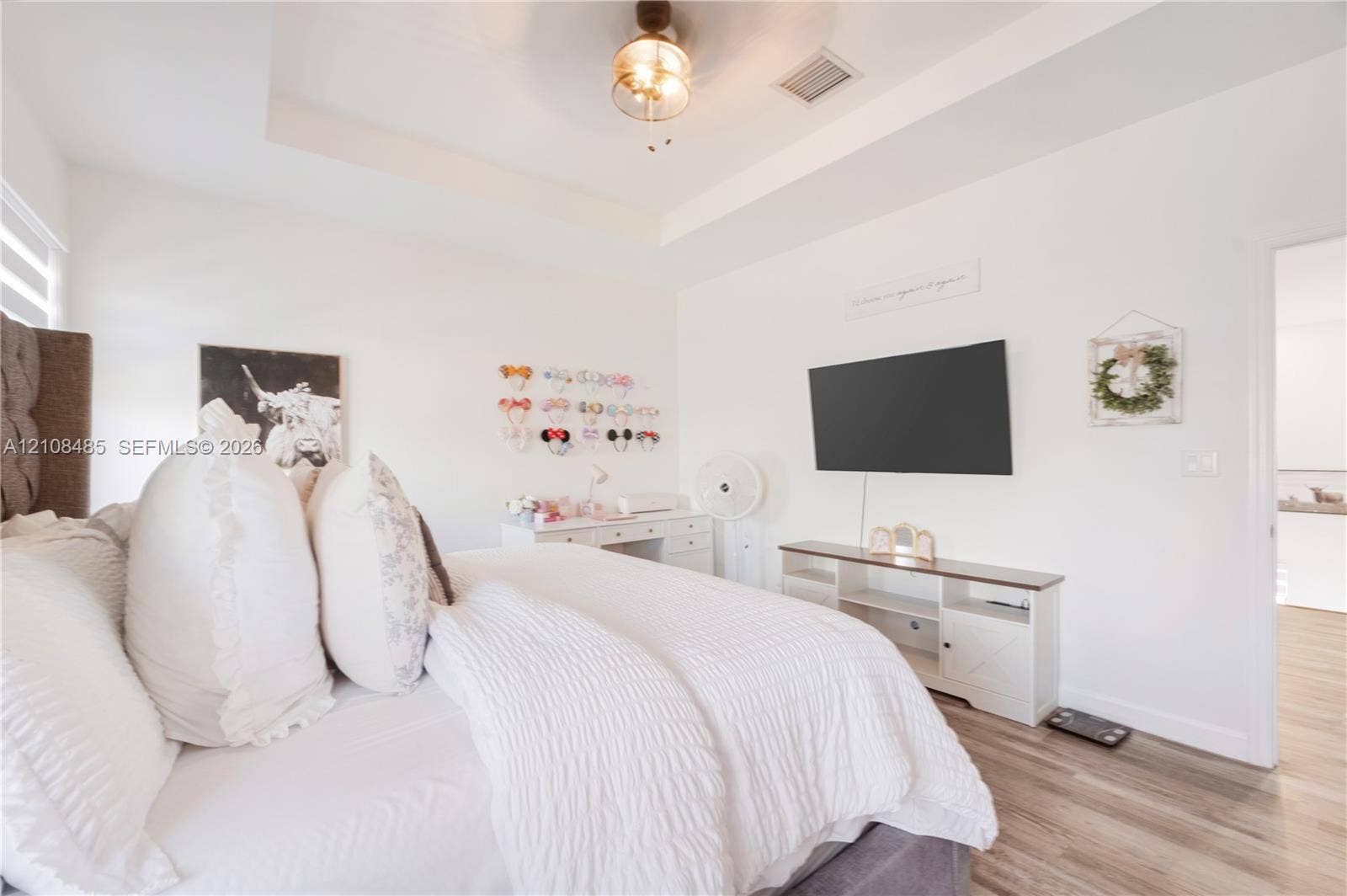 10217 SW 231st Lane, Miami, FL 33190 Tray ceiling featuring a central brushed-nickel ceiling fan with an integrated light fixture and wood-finish flooring