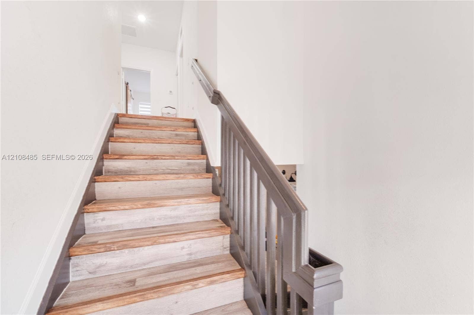 10217 SW 231st Lane, Miami, FL 33190 Staircase featuring wood-finish treads and a painted railing with vertical balusters