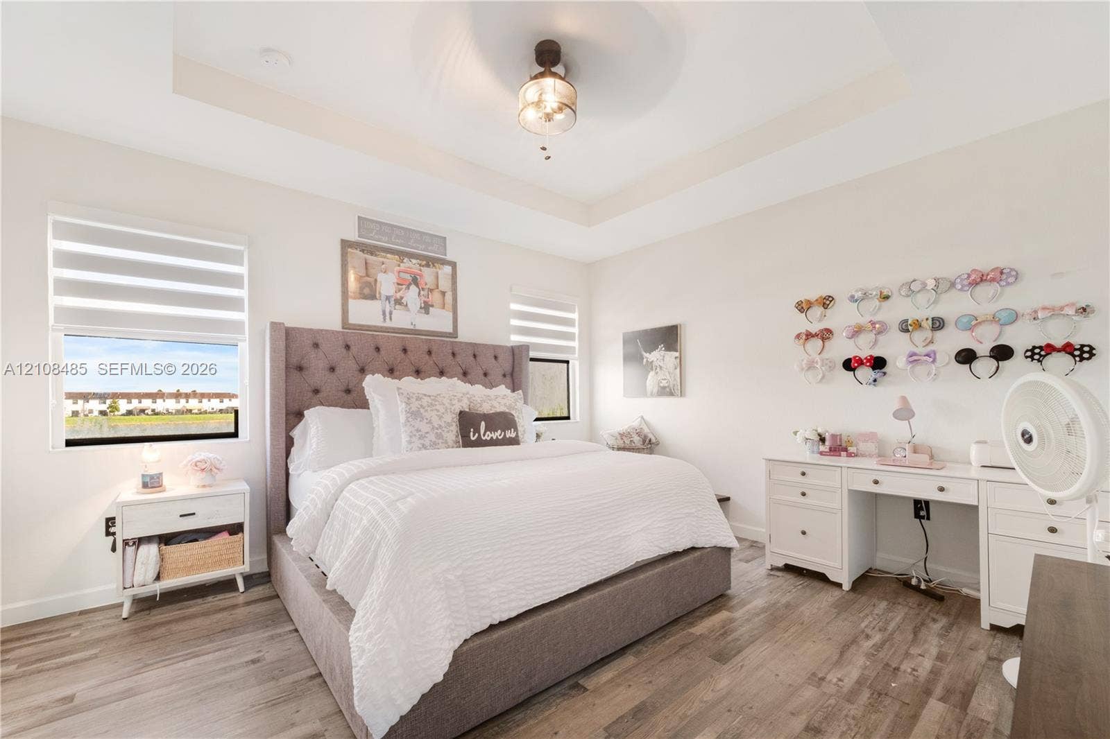 10217 SW 231st Lane, Miami, FL 33190 Tray ceiling with center-mounted light fixture, wood-finish flooring, and dual-layered window shades