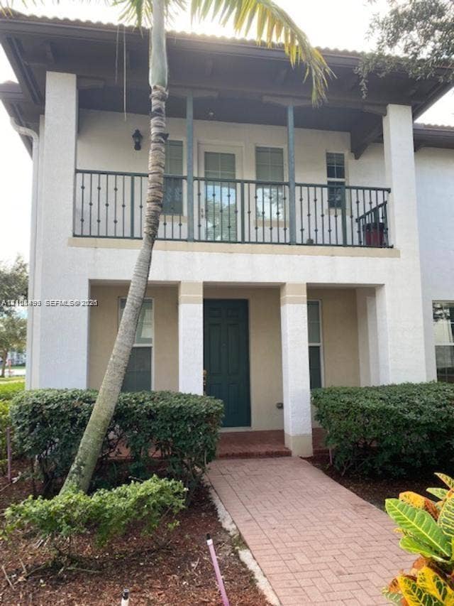 11835 SW 27th Street, #801, Miramar, Miramar, FL 33025 Two-story exterior featuring a second-level balcony with metal railing, a covered entryway, a brick-paver walkway, and structural support columns