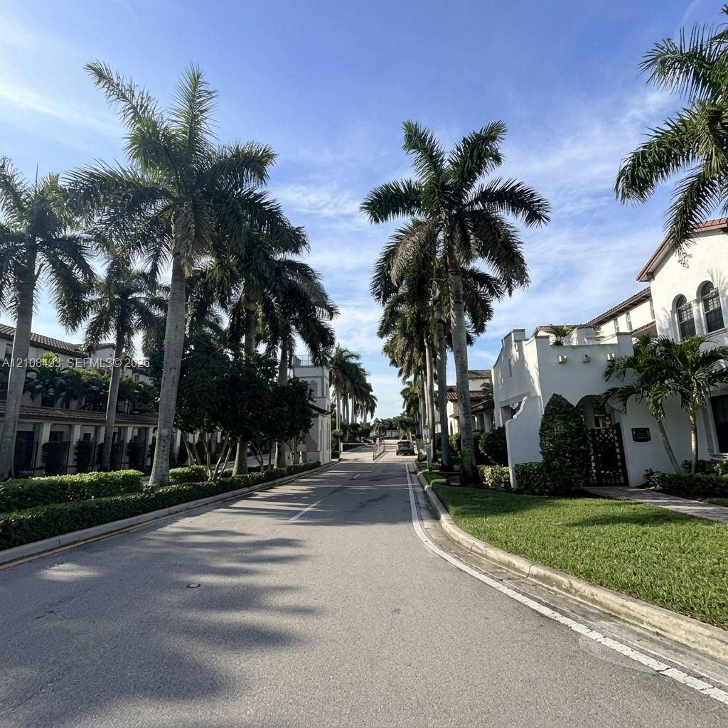 11835 SW 27th Street, #801, Miramar, Miramar, FL 33025 Paved thoroughfare lined with mature palm trees, manicured hedges, green lawns, and stucco building exteriors featuring arched windows