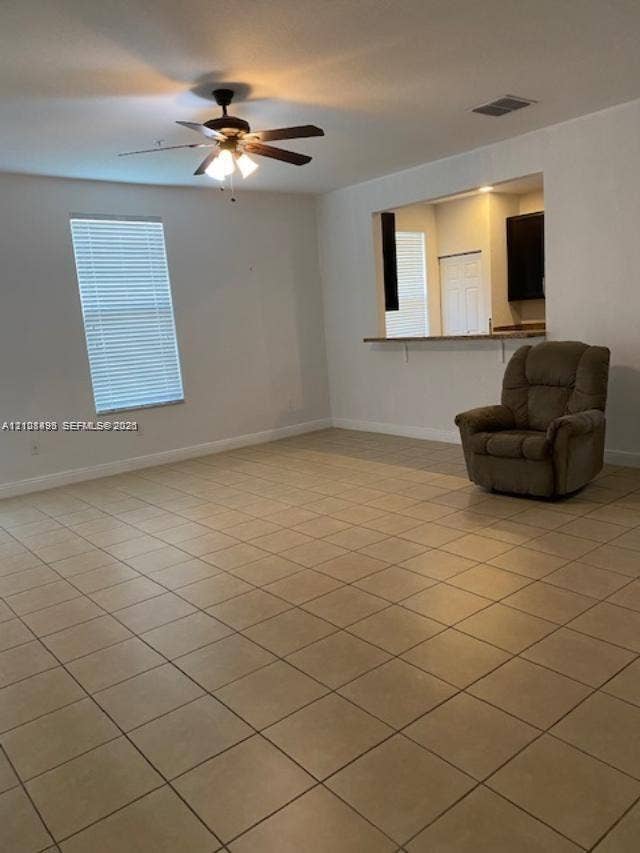 11835 SW 27th Street, #801, Miramar, Miramar, FL 33025 Neutral tile flooring, ceiling fan with light fixture, window with horizontal blinds, and a built-in pass-through window with counter ledge