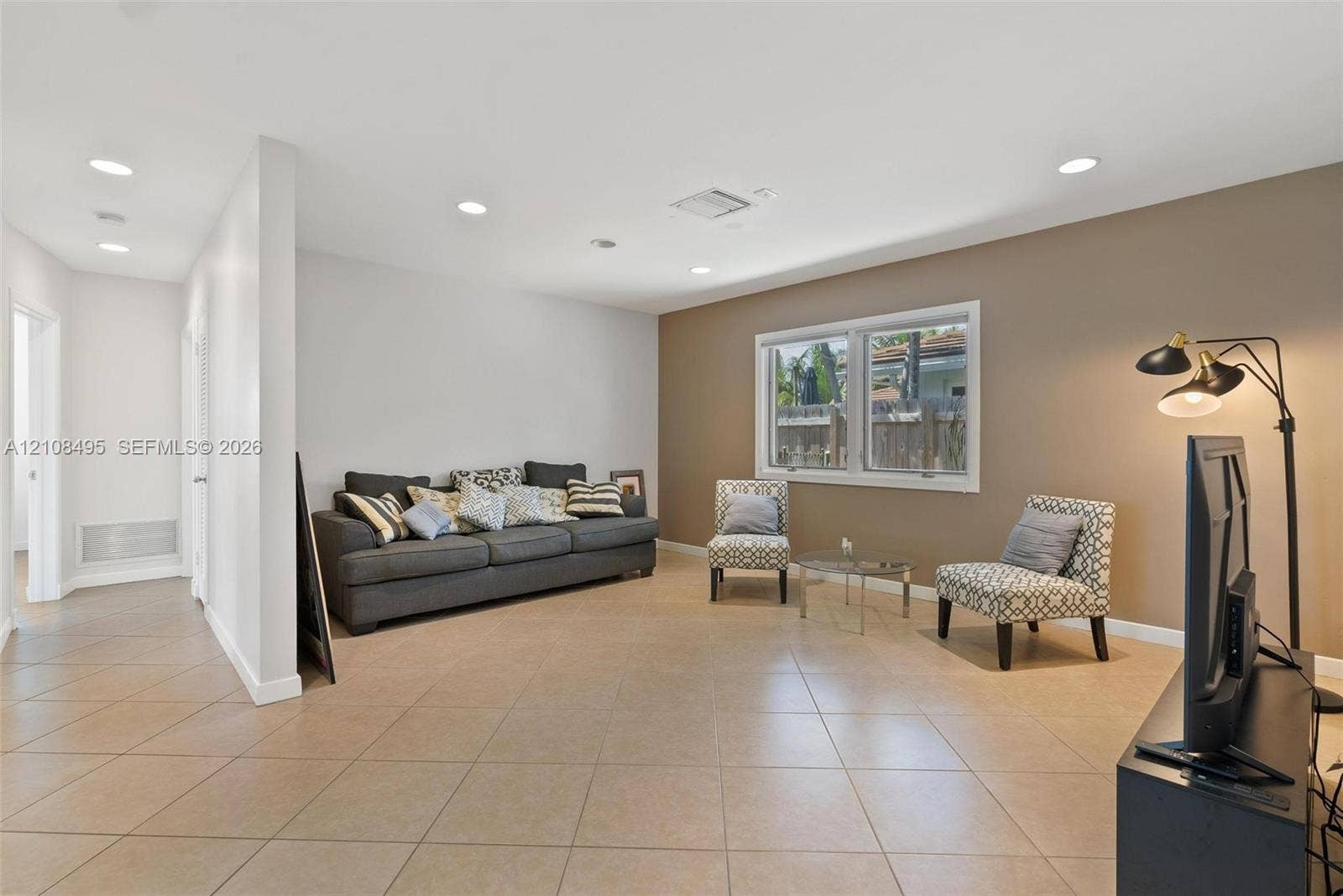 3080 NE 43rd Street, Fort Lauderdale, FL 33308 Neutral-toned interior space featuring light-colored ceramic tile flooring, recessed ceiling lighting, and a prominent dual-tone wall finish