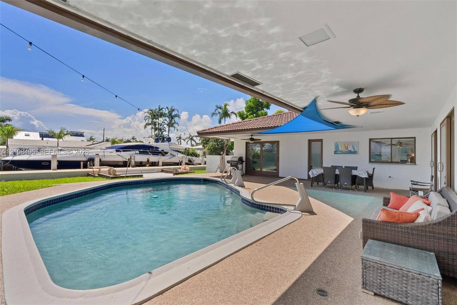 3080 NE 43rd Street, Fort Lauderdale, FL 33308 Covered outdoor patio with a ceiling fan, concrete pool deck, and an inground swimming pool with water access
