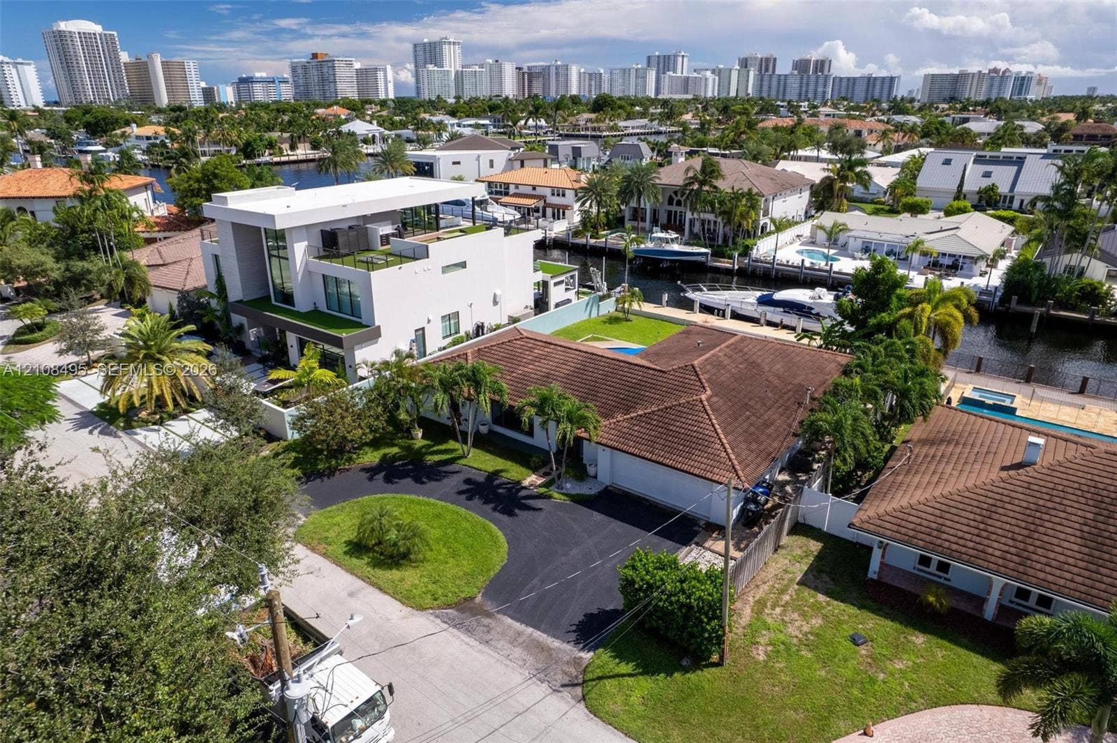 3080 NE 43rd Street, Fort Lauderdale, FL 33308 Waterfront property featuring a tile roof, paved driveway, swimming pool, and private boat dock
