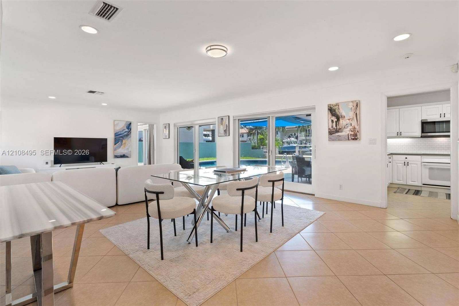 3080 NE 43rd Street, Fort Lauderdale, FL 33308 Open-concept interior featuring large-format tile flooring, recessed lighting, and multiple sliding glass doors providing outdoor access