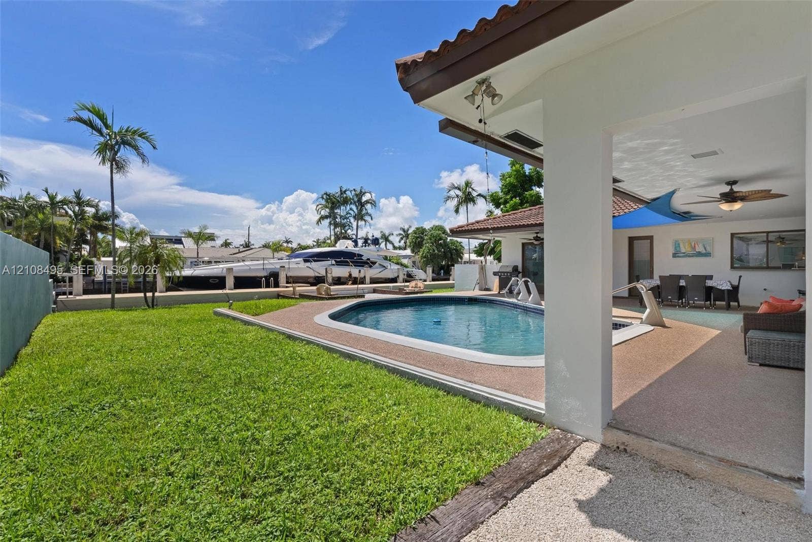 3080 NE 43rd Street, Fort Lauderdale, FL 33308 Covered patio with recessed lighting and ceiling fan, swimming pool with aggregate decking, and direct bulkhead access