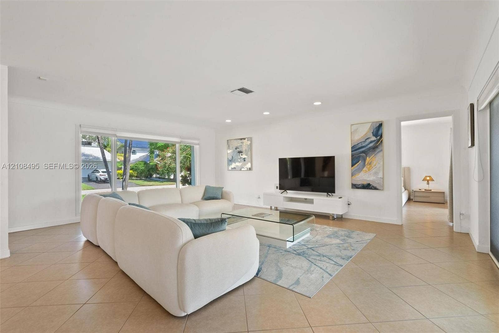 3080 NE 43rd Street, Fort Lauderdale, FL 33308 Open-concept interior featuring oversized tile flooring, recessed ceiling lighting, and large sliding glass windows