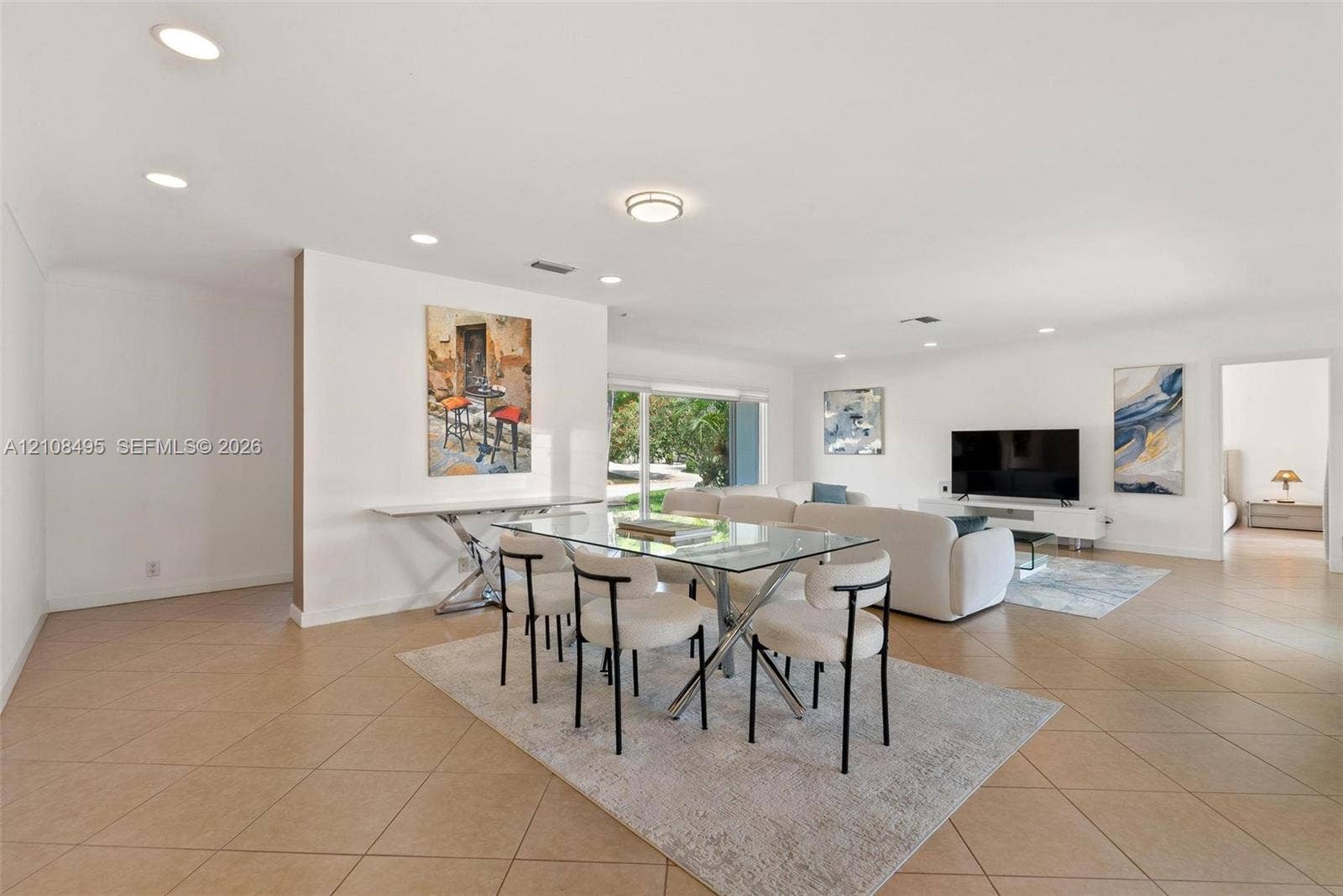 3080 NE 43rd Street, Fort Lauderdale, FL 33308 Open-concept living space featuring neutral ceramic tile flooring, recessed lighting, and large glass sliding doors