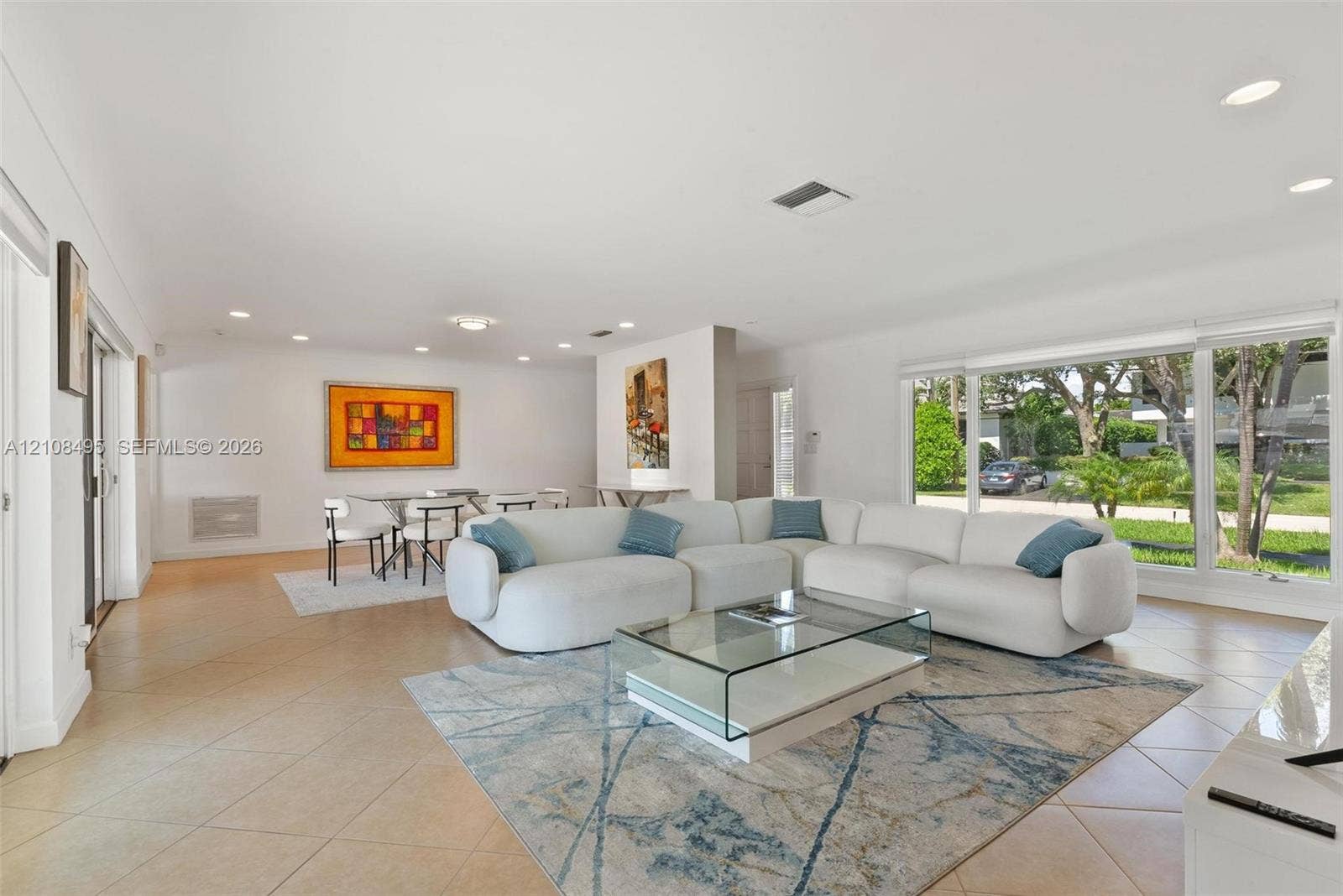 3080 NE 43rd Street, Fort Lauderdale, FL 33308 Open-concept living space featuring large-format ceramic tile flooring, expansive floor-to-ceiling windows, and recessed lighting