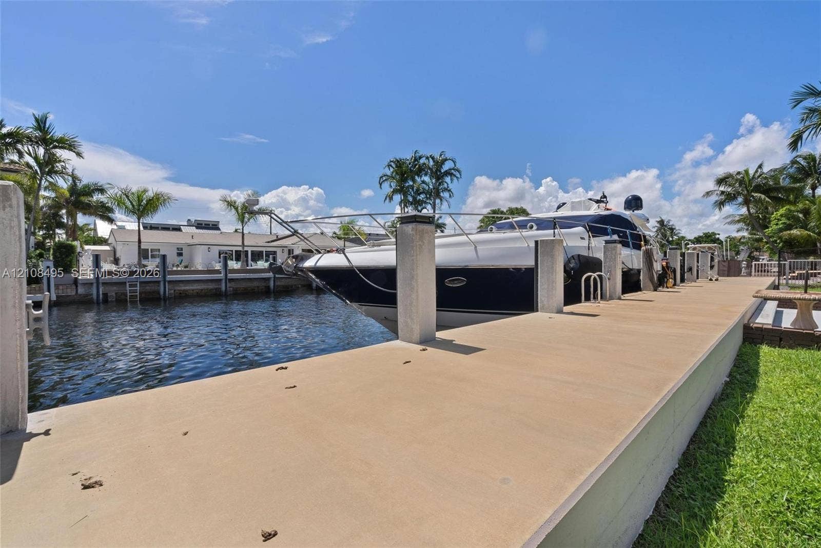3080 NE 43rd Street, Fort Lauderdale, FL 33308 Concrete deep-water dock featuring multiple pilings, integrated ladder access, and manicured grass perimeter