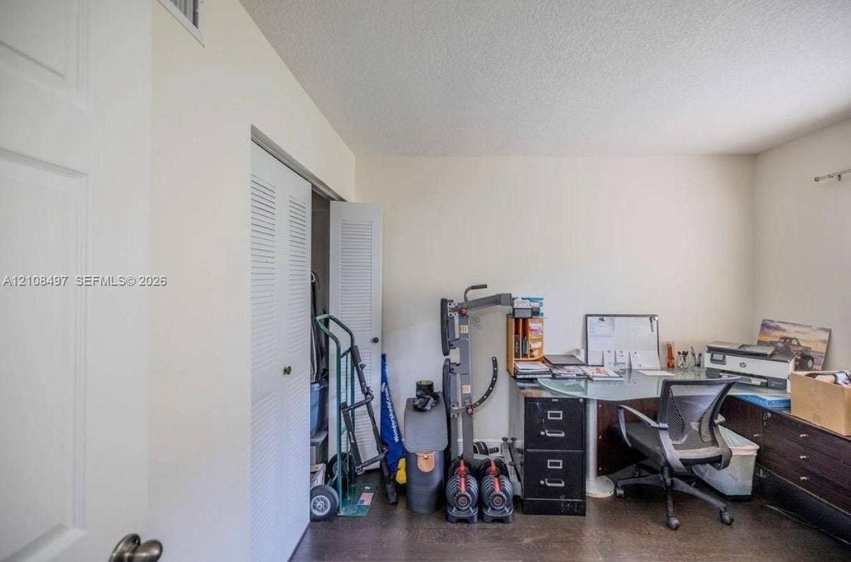 6245 SW 47th Manor, #101, Davie, FL 33314 Neutral-toned walls and dual louvered-door closet featuring interior storage space