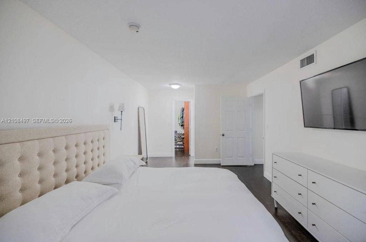 6245 SW 47th Manor, #101, Davie, FL 33314 Neutral color palette featuring dark wood-finish flooring, white walls, flush-mount ceiling lighting, and wall-mounted sconce fixtures